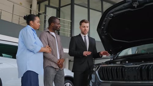 Customers Meeting Sales Person at Car Dealership