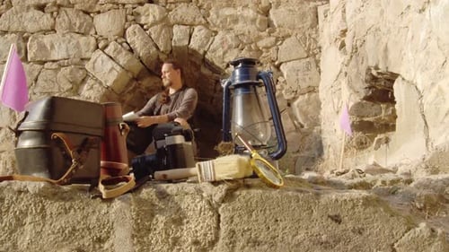 Historical Reconstruction of an Archaeological Expedition An Archaeologist Sits at an Excavation