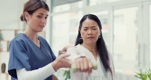 Woman Does Physical Therapy with Dumbbell