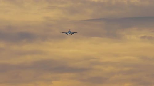 Flugzeug nähert sich am Sonnenuntergangshimmel