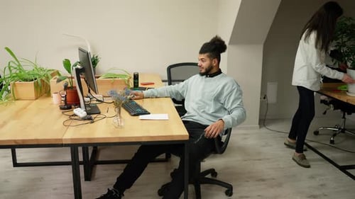 Jeune homme d'affaires travaillant calmement sur un ordinateur portable au bureau avec des collègues