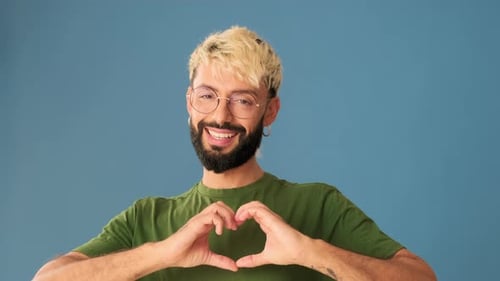 Man Making Heart Shape with Hands and Smiling
