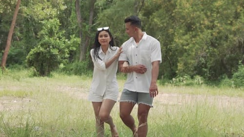 Asian couple young man and woman walking travel in forest happy romantic