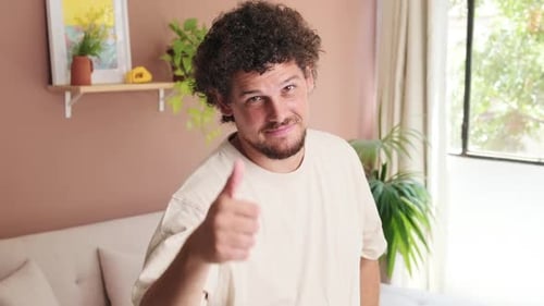 Young Adult Gives Thumbs-Up Indoors