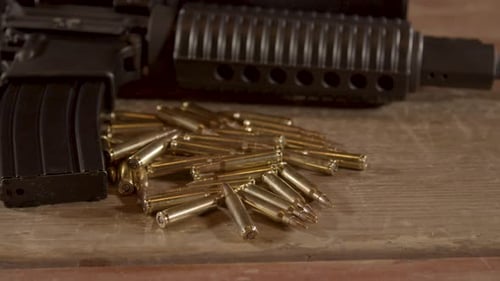 Dolly out of ammunition lying in front of AR-15 barrel