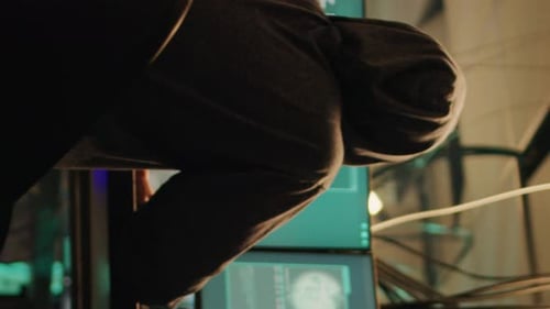 Hooded Hacker Working on Computer Late at Night