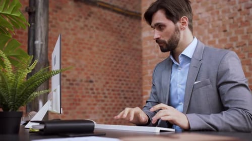 Young Businessman in Office Working on Pc and Looking at Camera