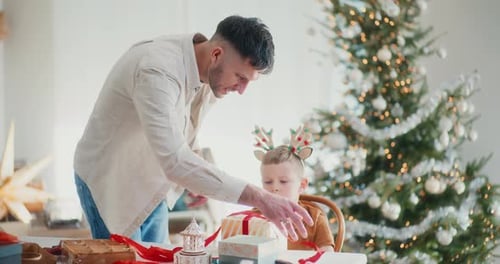 Father and Son Wrapping Christmas Gifts Together