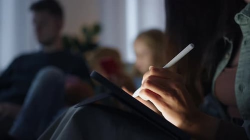 Woman Drawing on Tablet at Home with Family