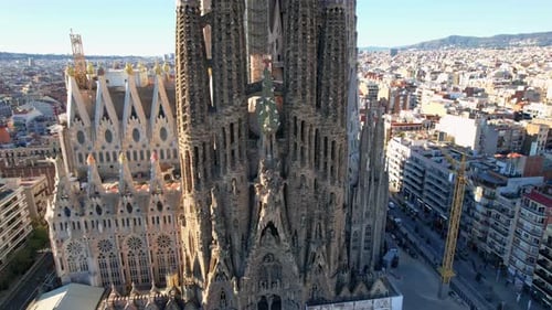 Drone shot, panning around of unfinished church Sagrada familia cathedral temple, over city