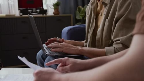 Couple reviews documents together on laptop at home