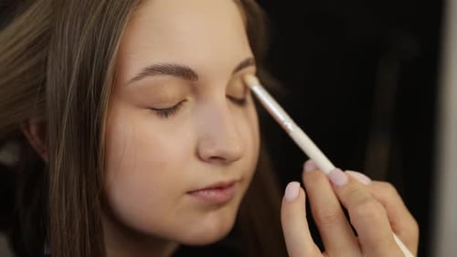 Makeup Artist Applying Eyeshadow on a Client