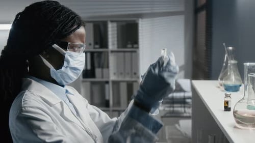 Scientist Working with Flask and Dropper in Lab