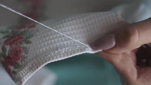Woman's Hands Sewing White Floral Fabric