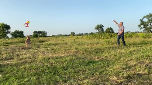 Girl and Man Fly Kite in Rural Field