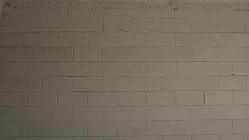 Un primer plano de una cámara que se mueve hacia una pared blanca de ladrillos de hormigón. Antecedentes.