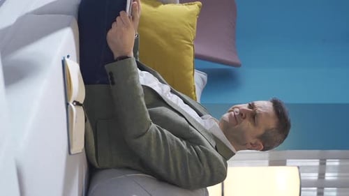 Man Reclining on Couch Working on Laptop