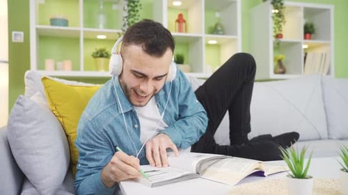 Man Listening to Music While Studying Indoors