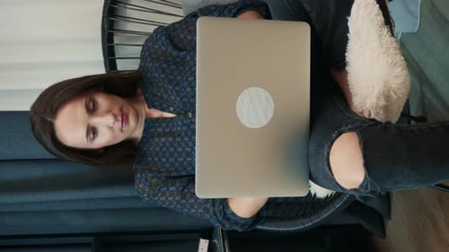 Woman Working on Laptop in Wire Chair
