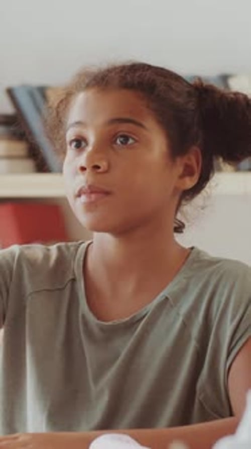 Diligent African American Girl Raising her Hand During Class in School