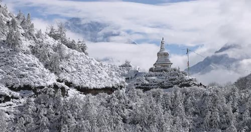 Slow motion of people walking along snow covered trail near a stupa in Nepal.