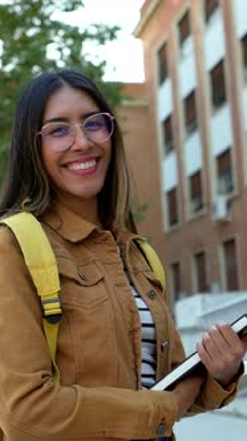 Smiling University Student Holding a Book on Campus
