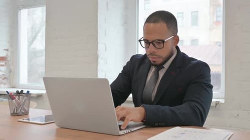 Adult Man Typing at Desk in Modern Office