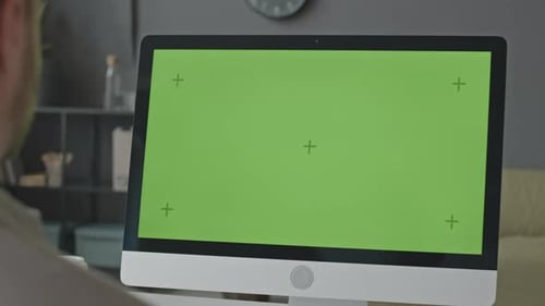 Büroangestellter schaut auf den grünen Vorlagenbildschirm auf dem Computer
