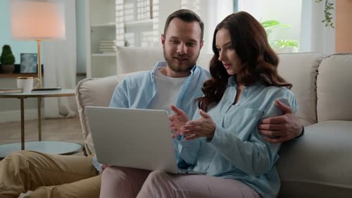 Affectionate Couple Using Laptop Together on Couch