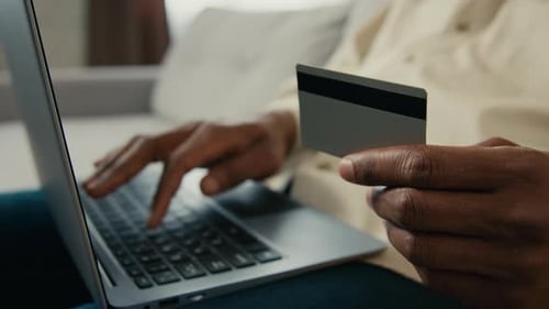 Man using Laptop and Credit Card Indoors