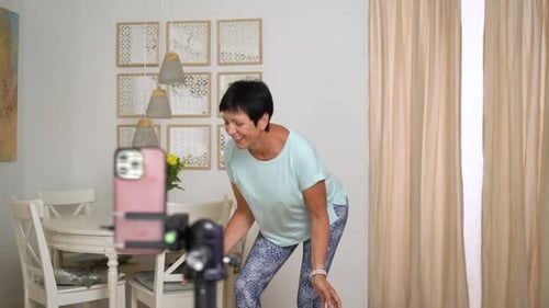 Reife Frau nimmt zu Hause trendige Tanzbewegungen für ein Social-Media-Konto auf