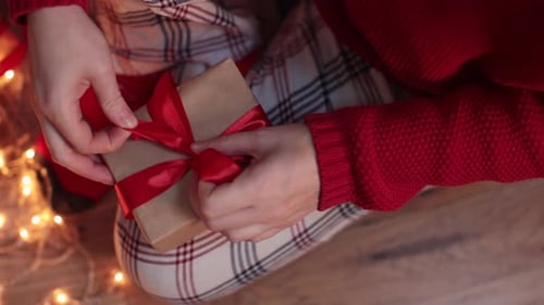 Person Tying Bow on Christmas Gift
