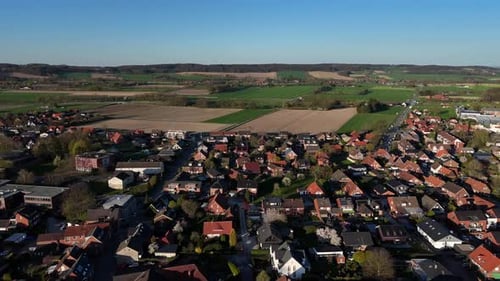 Housing area with row of homes in suburb area of american town. Aerial forward wide shot. Hilly farm