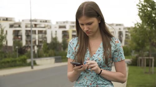 A Beautiful Young Caucasian Woman's Smartphone Malfunctions and She Gets Irritated in an Urban Area