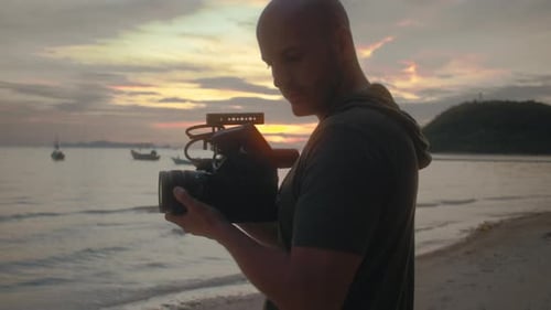 Videographer Filming Ocean at Dusk on Beach