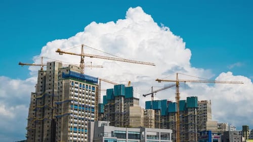 Time lapse Urban development of high-rise towers and building. Colorful tower cranes in cloudy day.