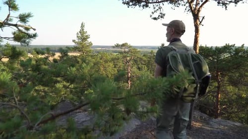 Man with Hiking Equipment Walking in Mountain Forest