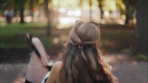 A mother with long wavy hair siting on a bench, breastfeeding her baby in a peaceful park, next to a