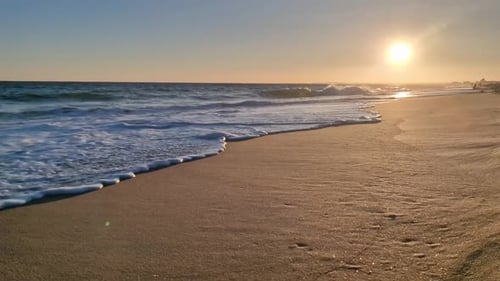 Golden Sunset on Beach Frothy Waves Roll on Sand of Beach Under Low Sunlight Slow Motion Videography