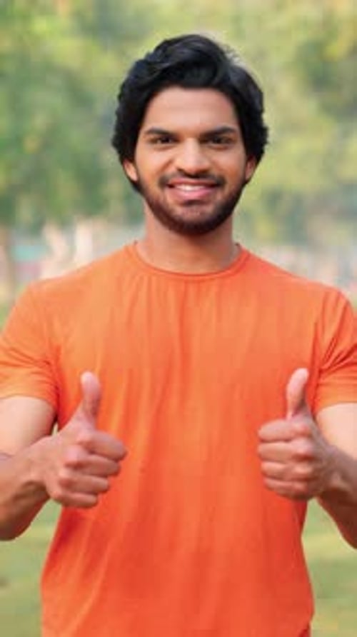 Smiling Man Giving Thumbs Up Gesture Outdoors