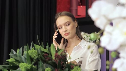 Smiling Woman Talking on Phone in Flower Shop