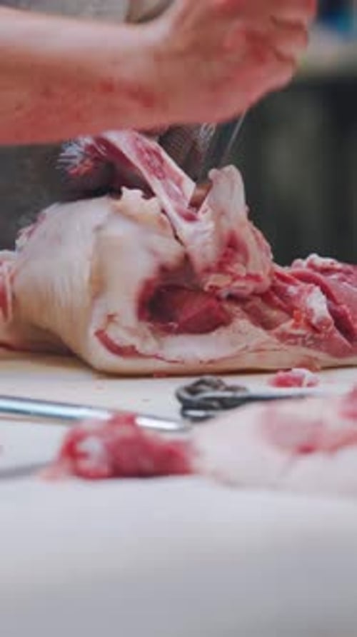 Butcher Chops Meat on White Cutting Board