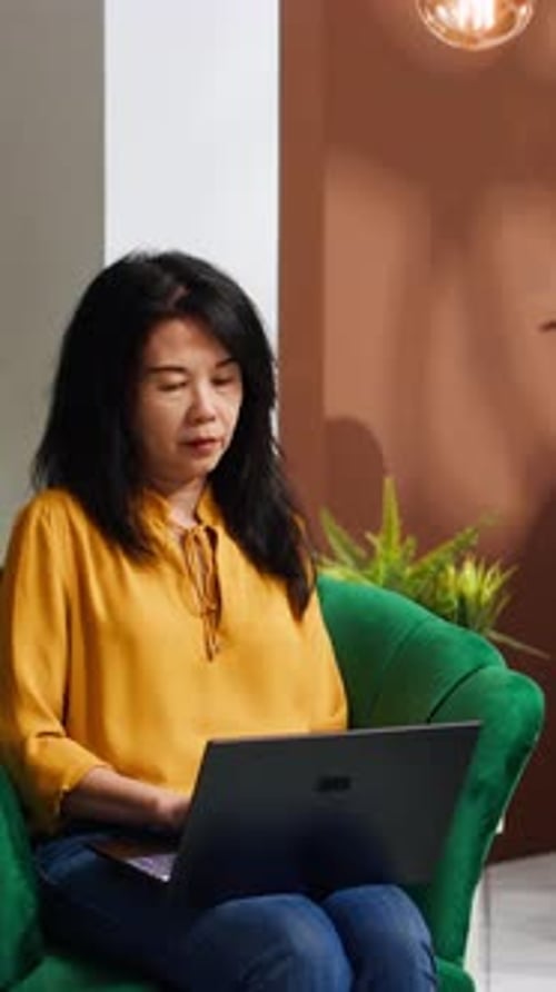 Woman Working on Laptop From Green Armchair
