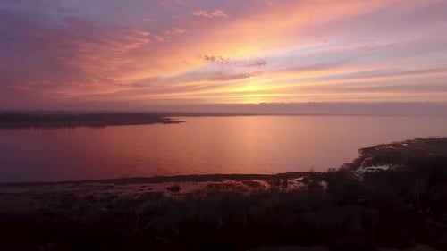 Lake Burtnieks im Spätherbst roter Himmel Sonnenuntergang Luftaufnahme mit Baumsilhouette