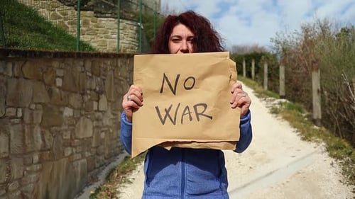 Woman Holding 'No War' Sign on Dirt Path