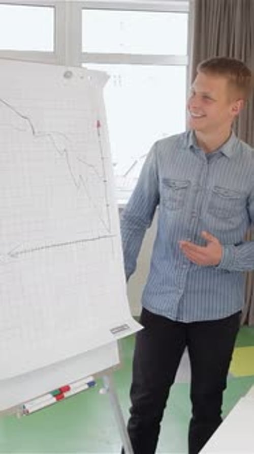 Engaged Man Presents a Detailed Chart in a Bright Modern Office