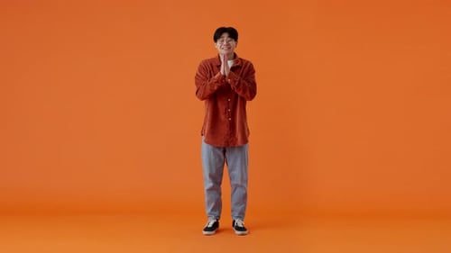 Asian Male Begging with Hands in Praying Position in Studio