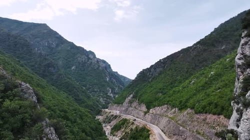 Aerial shot of empty mountain road revealing ravine