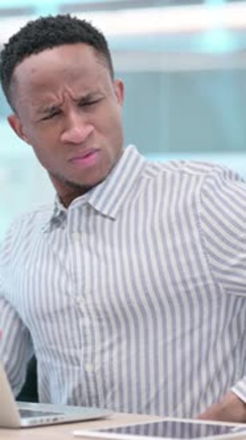 Young Man Experiencing Pain While Typing at Desk