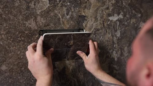 Man installs toilet flush button in marble wall